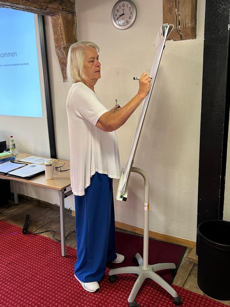 Susanne Smith-Hinz erläutert Inhalte an einem Flipchart während ihres Workshops.