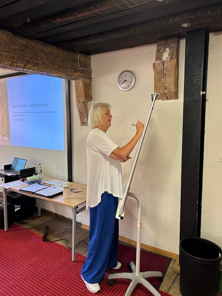 Susanne Smith-Hinz schreibt während eines Workshops an ein Flipchart.